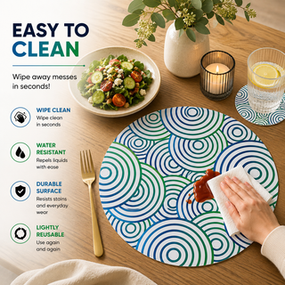 Modern Tropic round paper placemat, blue and green overlapping concentric circles, easy to clean as a hand wipes a spill beside a styled place setting