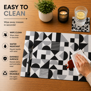 Monochrome Balance rectangular paper placemat, black and white Bauhaus geometric shapes, easy to clean as a hand wipes a spill beside a styled place setting