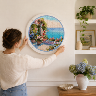 Person hanging the Mediterranean Balcony acrylic wall art puzzle on a living room wall