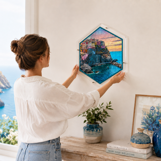 Person hanging the Amalfi Escape acrylic wall art puzzle on a living room wall