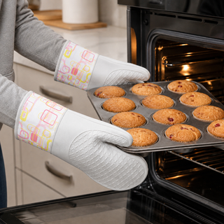 Retro Bake silicone oven mitts holding a hot baking tray from the oven