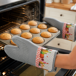 Vineyard Table silicone oven mitts holding a hot baking tray from the oven