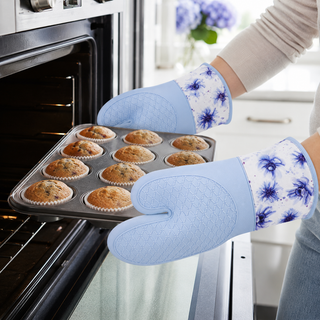 Spring Wildflower silicone oven mitts holding a hot baking tray from the oven